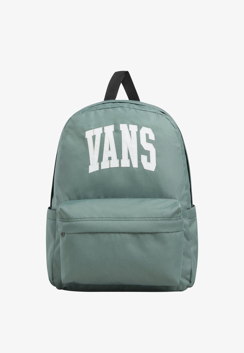 Vihreä kanvasreppu, jossa on suuri valkoinen "VANS"-logo, etutaskussa vetoketju ja mustat säädettävät hihnat. Pyöreä muoto ja sileä pinta.