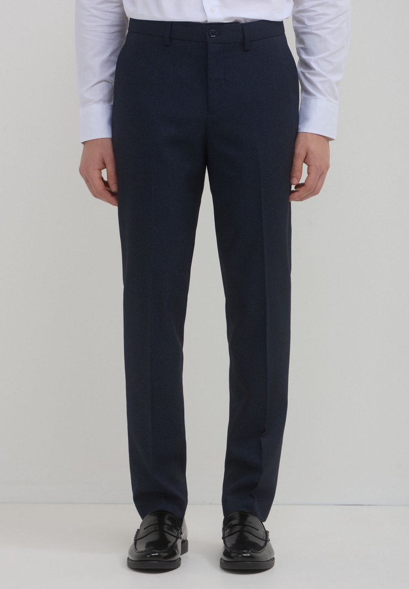 Pantaloni tailored blu navy in tessuto texturizzato, con un classico design a gamba dritta, chiusura con bottone e tasche laterali.