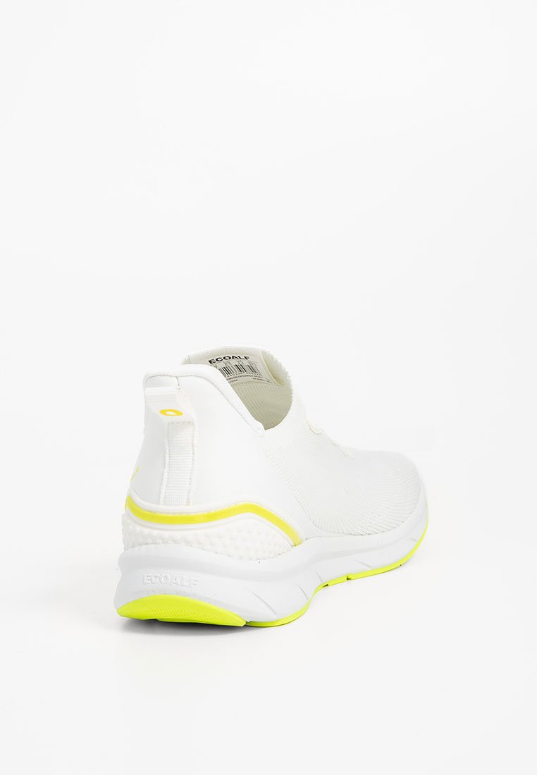 Zapatilla deportiva blanca con una parte superior de tejido texturizado, diseño sin cordones y un acento amarillo brillante en la suela y el talón trasero.