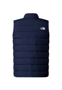 Mørkeblå isoleret vest med horisontalt quiltet design, høj krave og hvidt logo på den øverste venstre side. Glat tekstur, letvægts.