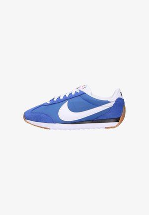 Zapatillas deportivas azules con un swoosh blanco, que presentan una combinación de materiales de ante y textil, cordones planos y una suela de goma.