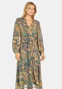 Sukienka w stylu kopertowym z przezroczystego materiału z wirującym, wielokolorowym wzorem w złocie, cieleni i burgundzie. Posiada długie rękawy oraz pasek w talii.