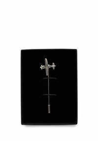 Silversimulerat flygplansbrosch utställd mot en svart sammetbakgrund; har intrikata detaljer och en nål för fäste.