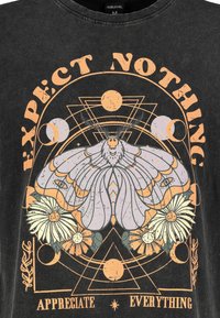 Black t-shirt with a graphic print featuring a moth, flowers, and geometric shapes. Text reads "EXPECT NOTHING" and "APPRECIATE EVERYTHING."