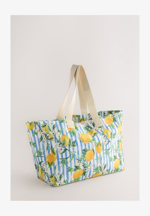 Duża torba na ramię z niebiesko-białym paskowanym wzorem, ozdobiona nadrukami cytryn i kwiatów; posiada beżowe uchwyty z tkaniny.