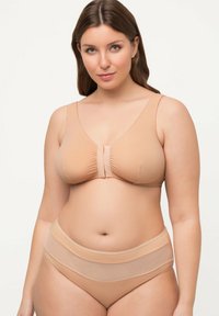 Sostén nude con un diseño de escote en V y tejido suave, con un centro fruncido y tirantes ajustables. Coquetos panties de talle alto a juego con acentos transparentes.