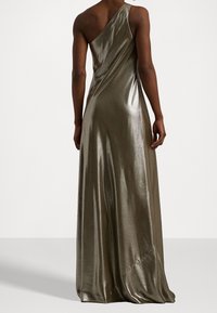 Robe métallique vert olive à une épaule avec un design épuré. Le tissu est lisse et se drape élégamment, présentant une silhouette longue jusqu'au sol.
