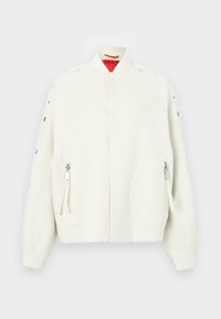 Λευκό μπουφάν bomber με ψηλό γιακά, κουμπιά τύπου κλιπ, πλαϊνές τσέπες με φερμουάρ και διακοσμητικές λεπτομέρειες με μεταλλικά κουμπώματα στα μανίκια. Μαλακή υφή υφάσματος.