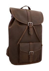 Sac à dos en cuir marron avec rabat et poche avant, tous deux sécurisés par des boucles argentées, et une petite poignée supérieure.
