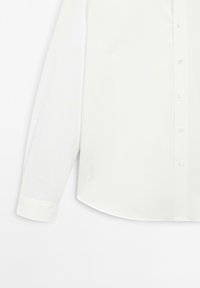 Weißes Langarm-Hemd mit Knöpfen, das eine glatte Textur, einen spitzen Kragen und einen abgerundeten Saum mit Bündchendetails an den Ärmeln aufweist.