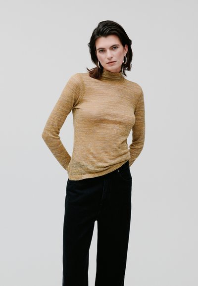 Long-sleeve turtleneck sweater in a textured mustard fabric, paired with high-waisted black pants. Simple design, fitted silhouette, minimal detailing.