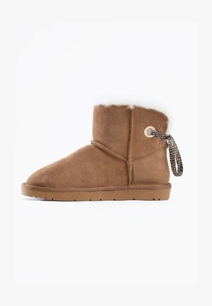 Braune Wildleder-Ankle Boots mit runder Zehenform, weichem weißen Fellfutter und einem dekorativen Leo-Print-Zugband auf der Rückseite. Flache Gummisohle.