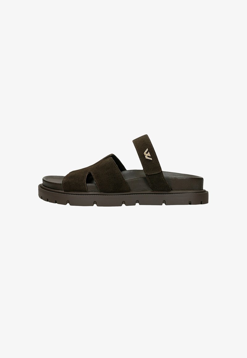 Sandale en daim brun foncé avec bout ouvert, deux larges brides sur le dessus du pied et une bride arrière avec un petit logo métallique.