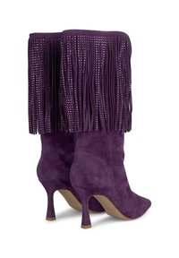 Bottes en daim violettes montant jusqu'au genou avec un design à franges, présentant des accents métalliques, des bouts pointus et des talons fins.