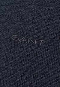 Marineblauer Strickpullover aus strukturiertem Stoff, mit einem dezenten GANT-Logo in kontrastierendem Grau auf der Vorderseite gestickt.