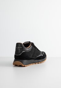 Baskets noires en daim et cuir avec semelle texturée, lacets noirs et logo « Pepe Jeans London » sur le talon, vues de l'arrière.