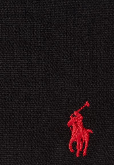 Juodas tekstūruotas audinys su mažu raudonu siuvinėtu polo žaidėjo logotipu dešiniajame apatiniame kampe.