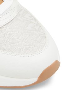 Weißer Sneaker mit einem strukturierten Obermaterial aus Stoff und einem dezenten Muster, Lederakzenten und einer Gummisohle. Runde Zehenform.