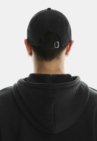 Căciulă de baseball neagră cu vizieră curbată și curea ajustabilă la spate, purtată împreună cu un hanorac negru cu glugă.