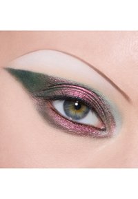 Dramatisk øjenmakeup med glitrende lyserøde og grønne gradienter, skarpt vingeeyeliner og en glat, lys brynhighlight mod hudtonen.