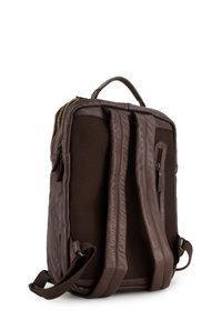 Bruine leren rugzak met een gevoerde mesh achterkant, verstelbare schouderbanden en een handvat bovenaan voor het dragen. Ritssluiting en details van zijvak.