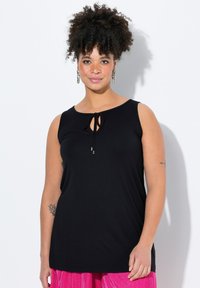 Czarny bezrękawnik z okrągłym dekoltem i detalem w postaci wiązania z przodu. Miękki materiał, luźny krój i gładka tekstura.