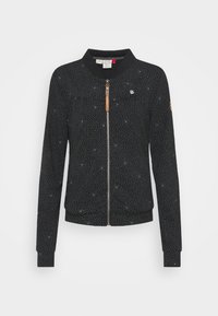 Svart bomberjacka med vitt prickmönster, dragkedjestängning, ribbad krage och muddar, med en liten logotyp patch och läderdetaljer.