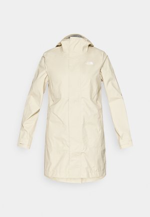 Világos bézs vízálló dzseki magas gallérral, hosszú ujjakkal és logó díszítéssel. Egyenes szabású, két oldalzsebbel.