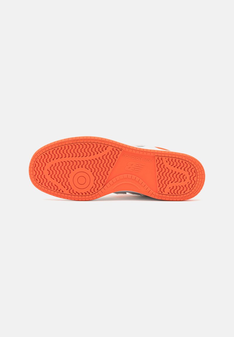 Suela de zapato de goma naranja brillante con patrones de agarre texturizados; presenta el logo y un diseño de banda de rodadura distintivo para tracción y durabilidad.