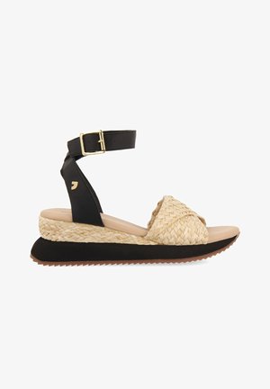 Sandale à talon compensé avec tige tissée beige, bride de cheville noire avec boucle dorée, et semelle noire texturée. Semelle intérieure beige lisse.