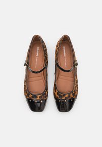 Bailarinas con estampado de leopardo, punta negra de charol, correa con hebilla y acentos de remaches; interior suave con plantilla ligeramente acolchada.