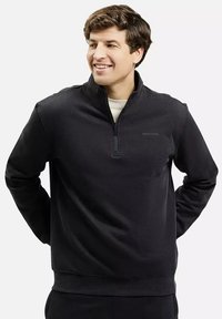 Czarny sweatshirt z pół zamkiem błyskawicznym, z długimi rękawami, z miękkiego materiału. Posiada ściągacze na mankietach i dolnym końcu oraz minimalistyczne logo na piersi.