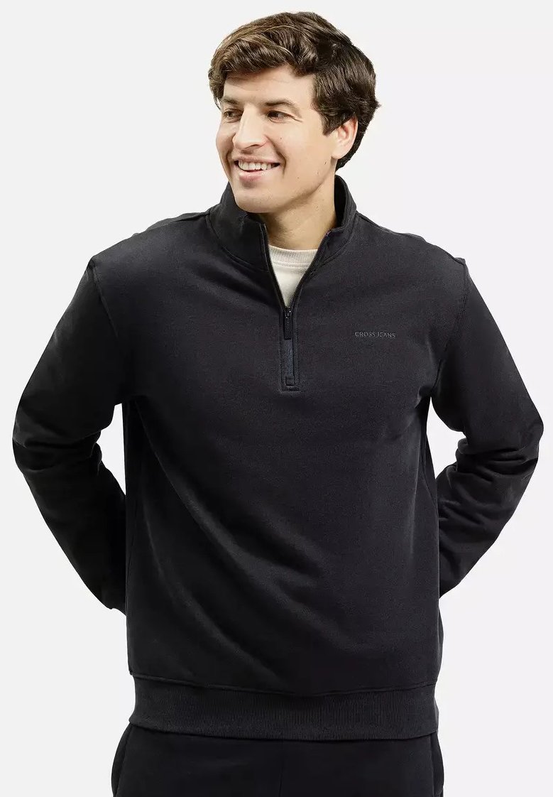 Czarny sweatshirt z pół zamkiem błyskawicznym, z długimi rękawami, z miękkiego materiału. Posiada ściągacze na mankietach i dolnym końcu oraz minimalistyczne logo na piersi.