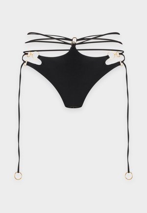 Slip bikini nero con molteplici sottili cinturini, dettagli con anelli dorati e lunghi lacci laterali su sfondo bianco semplice.
