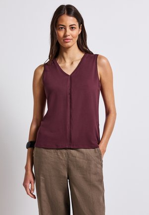 Top sans manches bourgogne avec un décolleté en V et un détail de couture à l'avant, fabriqué à partir d'un tissu lisse. Associé à un pantalon ample, marron clair.