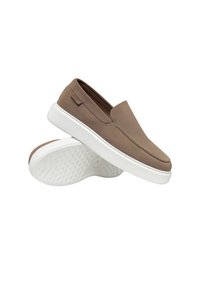 Chaussures décontractées marron à enfiler avec semelles épaisses en caoutchouc blanc, une chaussure inclinée pour montrer la semelle texturée, détails de couture minimaux.