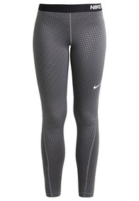 Legginsy Nike z geometrycznym wzorem w odcieniach szarości, z czarnym elastycznym pasem w talii i białym logo Nike na górze.