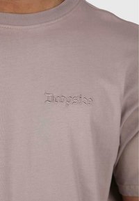 Short-sleeve, light mauve t-shirt made of soft cotton. Features small embroidered "Dropsize" text on the left chest area.