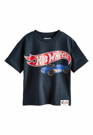 Black short-sleeve shirt with large red and white "Hot Wheels" logo and blue race car graphic on front, and small racing patch near hem.
