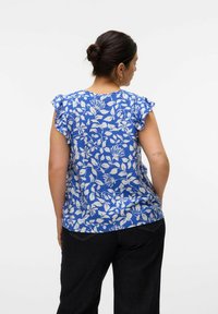 Blå blomstret bluse med korte, flæseærmer, der har et hvidt botanisk mønster. Let tekstureret stof og afslappet pasform.