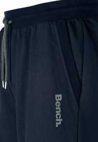 Marine joggings gemaakt van zachte stof, met een elastische tailleband en een grijze trekkoord, en een geprinte "Bench" logo aan de zijkant.