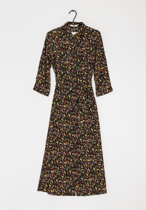 Czarna sukienka w kwiaty z rękawami o długości trzech czwartych, z cinchowanym wcięciem w talii i spódnicą do kolan z kolorowymi wzorami kwiatowymi.