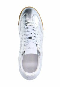 Zilveren metallic sneaker met een gladde, glanzende oppervlakte, witte veters en een tan rubberen zool. Opvallende branding op de tong.