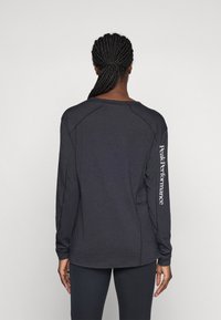 Dark grey long-sleeve athletic shirt with a rounded neckline, flat seams, and "Peak Performance" text along the left sleeve.