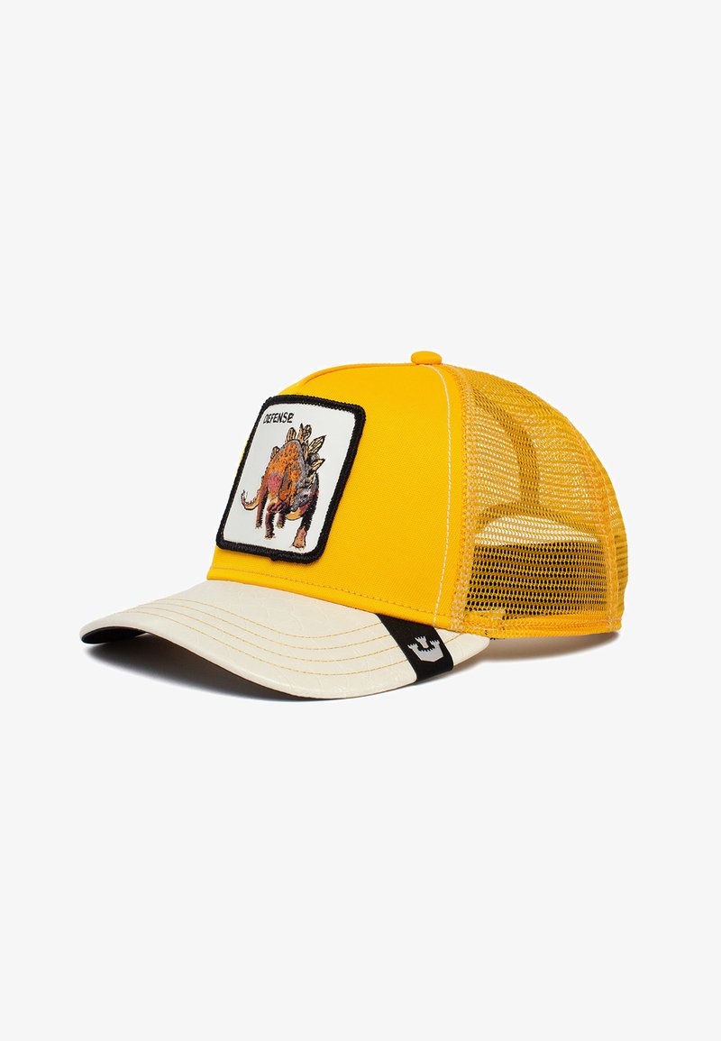 Gorra de camionero amarilla con parte trasera de malla, que presenta un parche frontal con una ilustración de un dinosaurio, visera beige y etiqueta de acento negra.