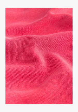 Tuvplāns mīkstai, krokaina rozā auduma virsmai ar smalku tekstūru un pinumu, kur gaisma un ēnas akcentē krokas.