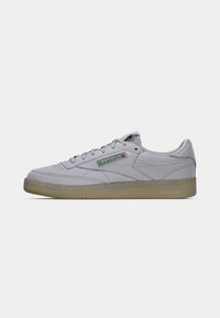 Gray leather sneakers with a textured finish, featuring a green and red Reebok logo, round toe, and a gum rubber outsole.