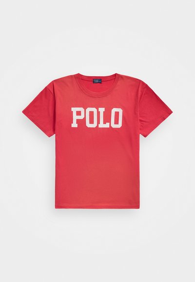 Tricou din bumbac roșu, cu guler rotund, mâneci scurte și cu "POLO" imprimat cu litere albe îndrăznețe pe piept. Textură netedă, croială clasică.
