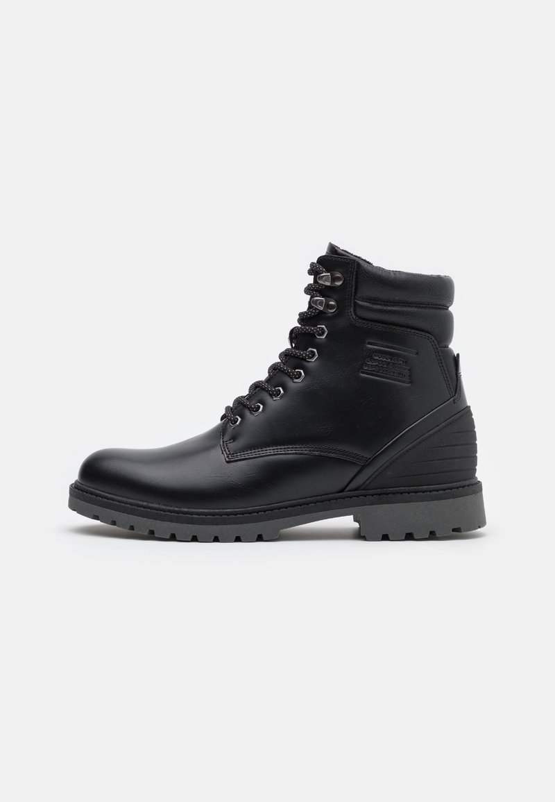 Bottine en cuir noir avec col rembourré, laçage à l'avant, œillets en métal, semelle épaisse et crampons robustes pour une utilisation en extérieur.