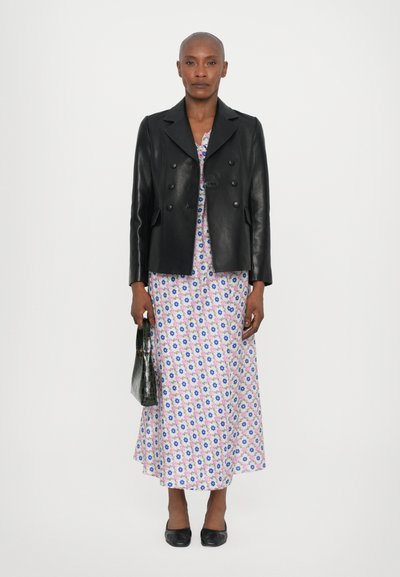 Black leather double-breasted jacket over a floral-patterned pink dress, accessorized with a dark green handbag and black flats.